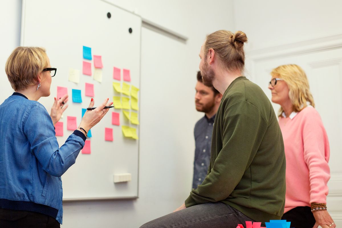 Colleagues mapping conversations with sticky notes on a board
