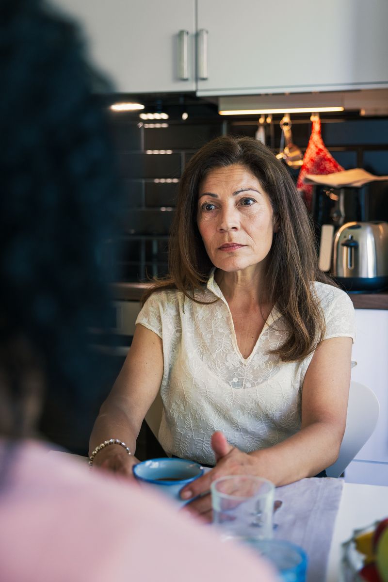 An employee listening seriously in a conversation at a table