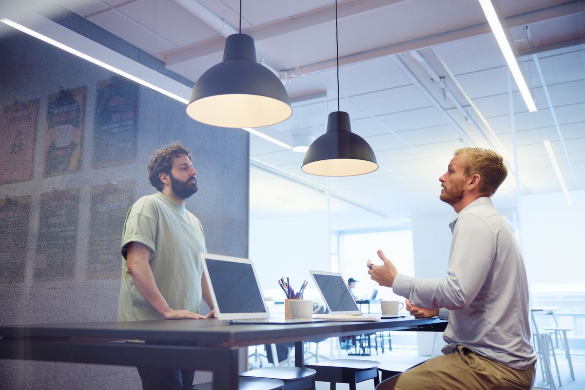 A manager and a new employee going through the work at a desk